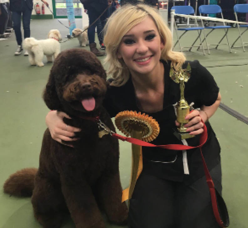 A dog groomer collects her trophy