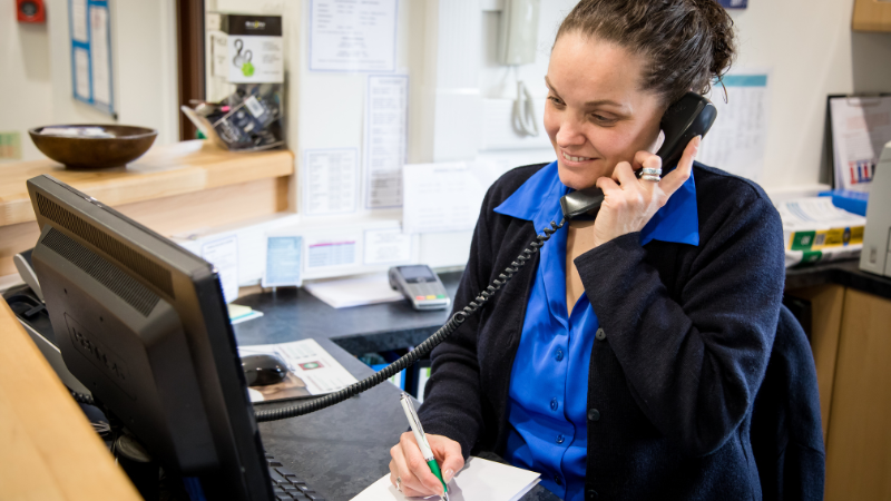 Veterinary Receptionist speaking to a pet owner on the phone.