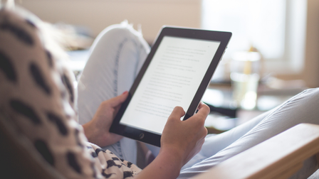 Person reading a kindle on a chair