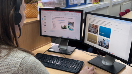 Tutor delivering a Live Online lesson, sat at desk on a computer wearing a head set