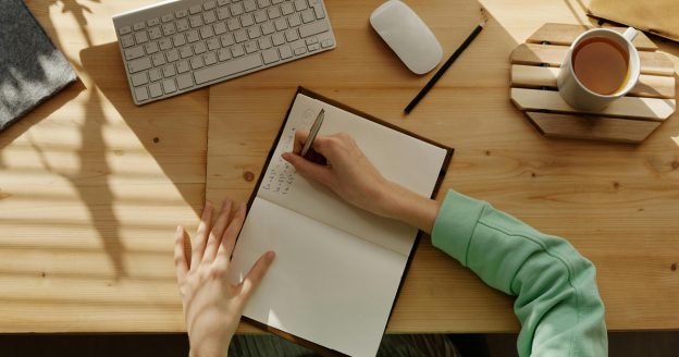 Student studying at a desk writing in a notebook
