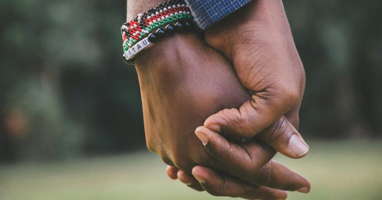 Two black people holding hands
