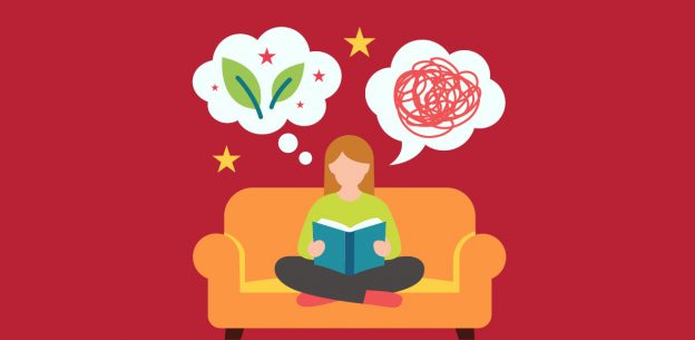A female student sitting on a sofa reading a book