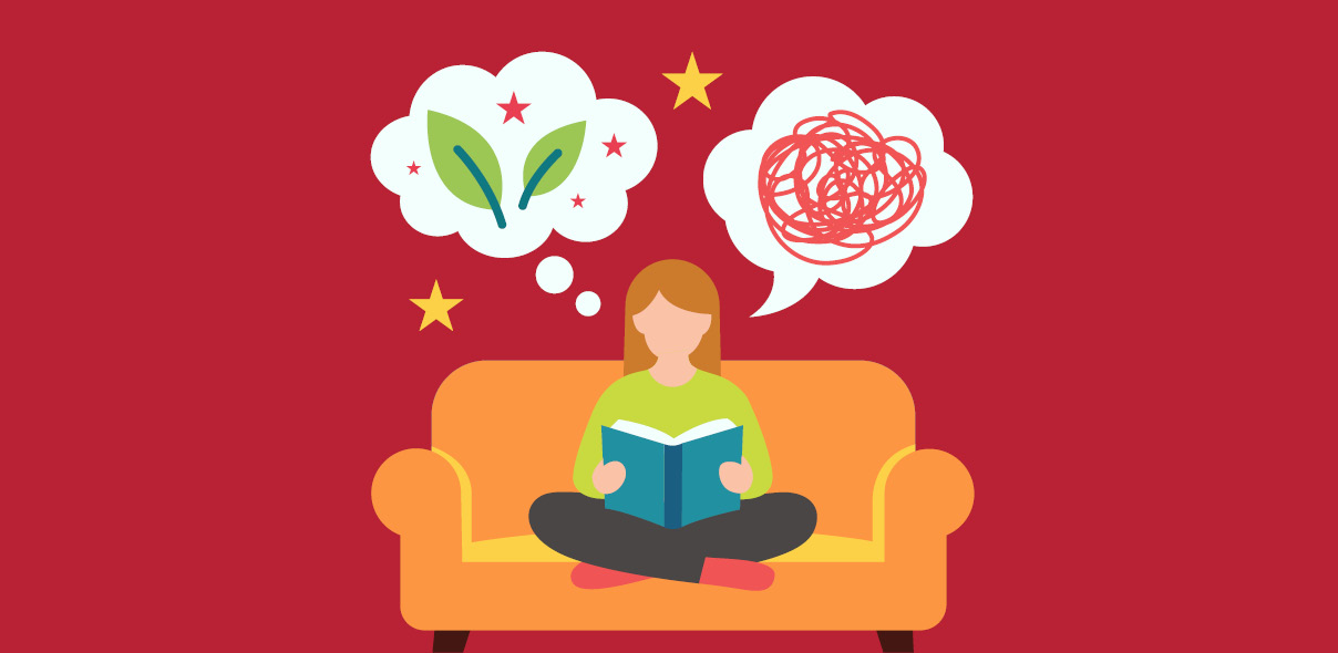A female student sitting on a sofa reading a book